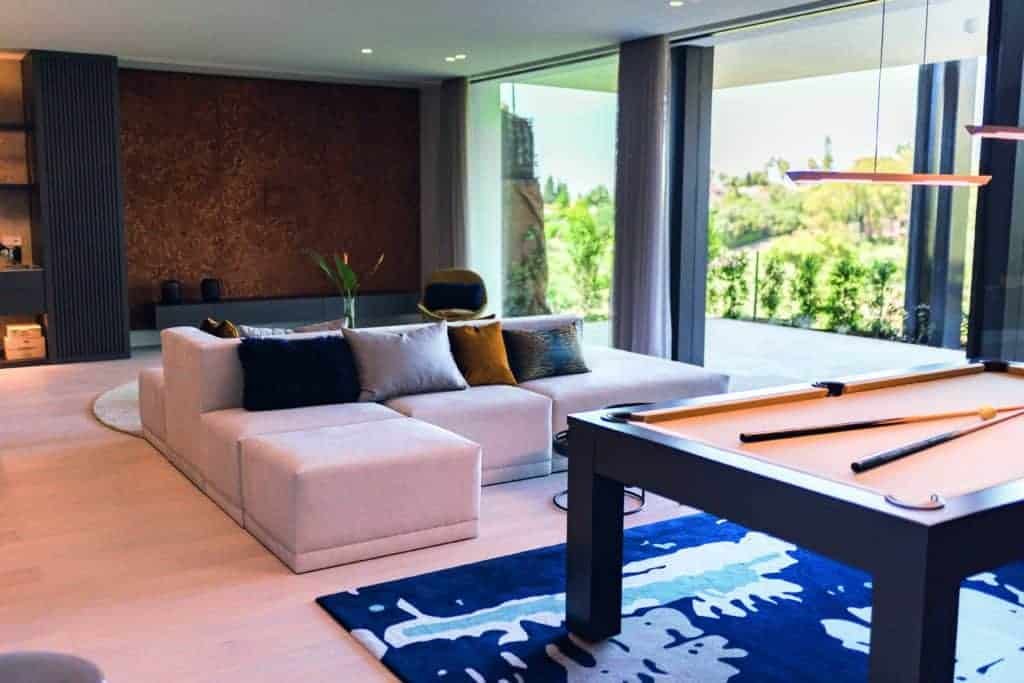 A sunlit home with a pool table in the living room.