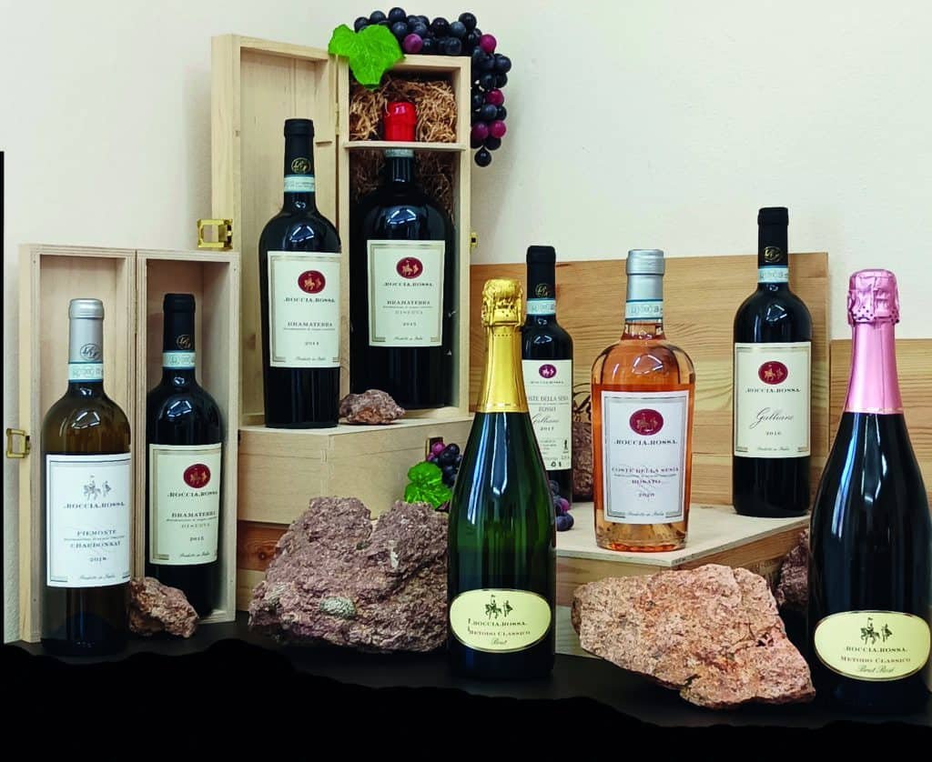 A group of bottles of Piedmont wine in a wooden box.
